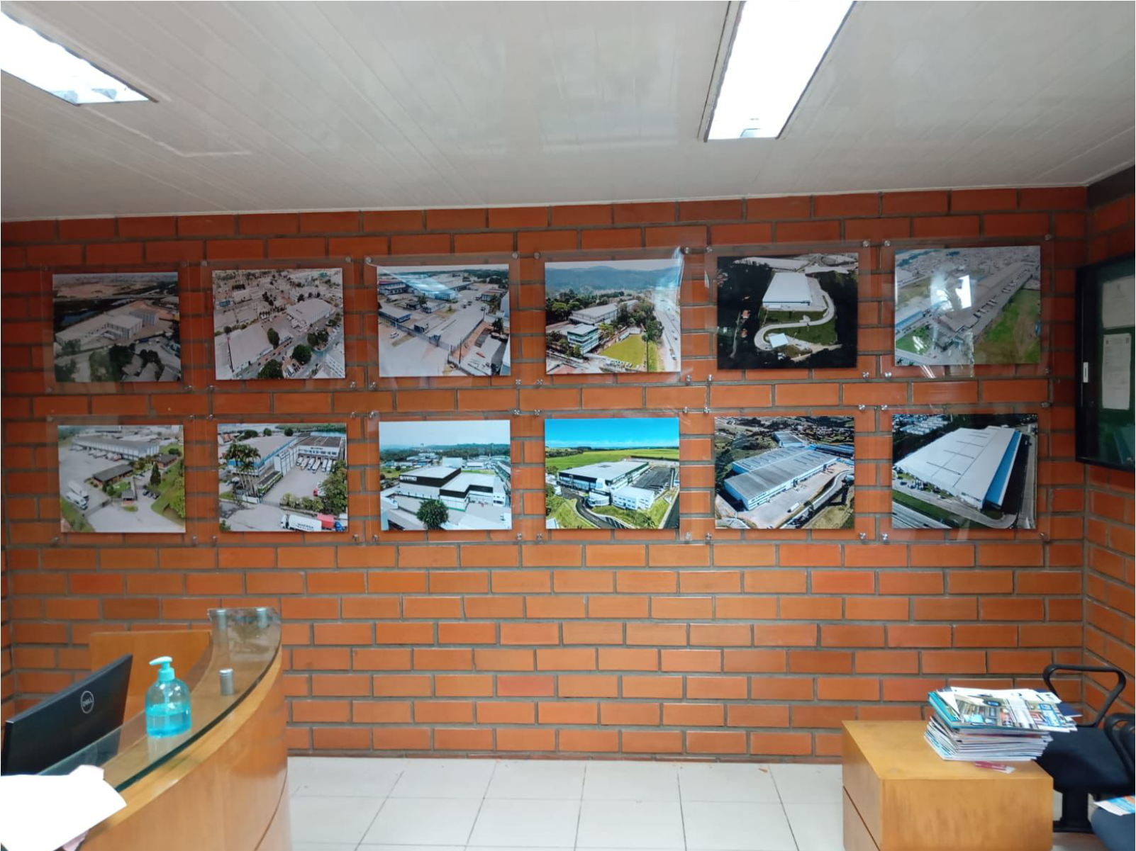 Painel de fotos em acrílico fixadas em parede de tijolos